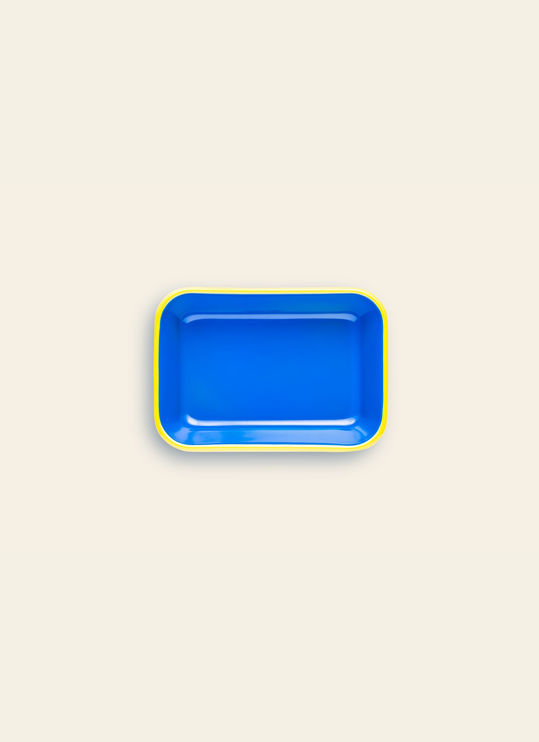 The Bornn Enamelware Colorama Baking Dish, Medium, is a rectangular blue tray with rounded corners and a yellow rim, handmade by Bornn Enamelware and shown against a plain light beige background.