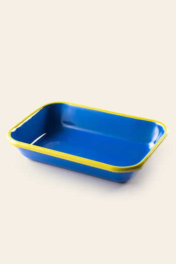 The Bornn Enamelware Colorama Baking Dish, Medium, by Bornn Enamelware, features a handmade rectangular blue design with a yellow rim, displayed against a light background.