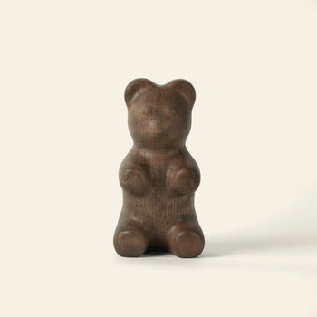 The Boyhood Gummy Bear Small by Boyhood is a smooth, dark brown sculpture shaped like a gummy bear, standing upright against a light background—an irresistible piece of eye candy.