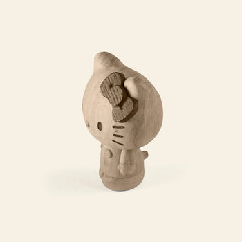 The Boyhood Hello Kitty Small by Boyhood is an unfinished wooden figurine with a bow, standing upright against a light background—ideal for fans of wooden collectibles or those fond of cherished childhood memories.