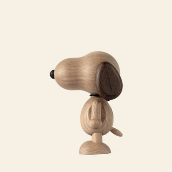 The Boyhood Snoopy Small by Boyhood is a minimalist wooden figurine with a large head, dark brown ears, and a round tail, shown in profile facing left against a plain light background.