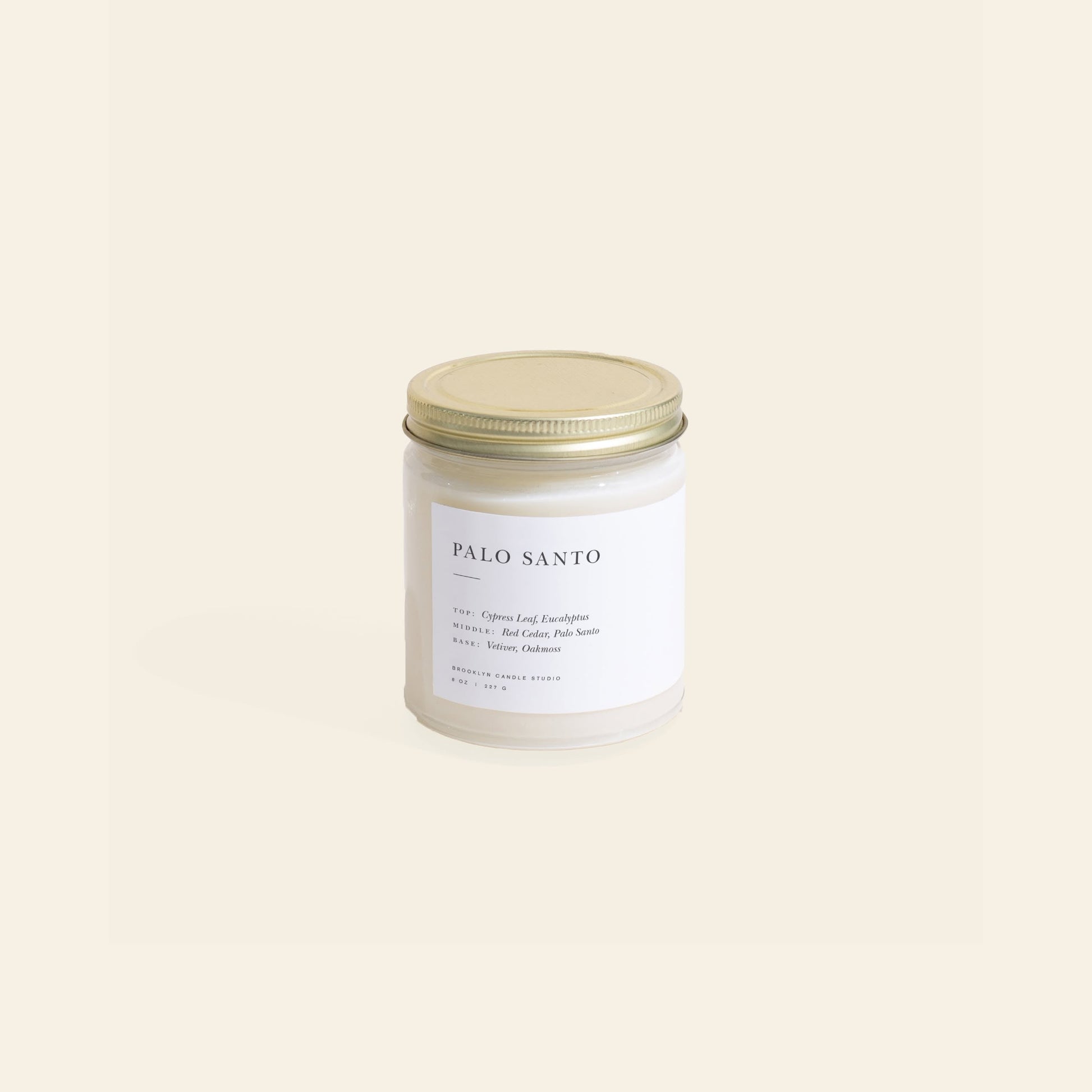 The Brooklyn Candle Studio Palo Santo Jar Candle, featuring a minimalist white label and gold metal lid, sits against a light beige background, inspired by the cleansing rituals of the sacred Palo Santo tree.