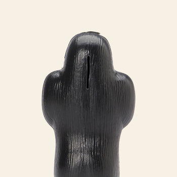 The DETAIL Gorilla Bank Small by DETAIL is a black, textured ape-shaped coin bank with a slot on top, set against a plain beige background—a unique decorative accent for any space.