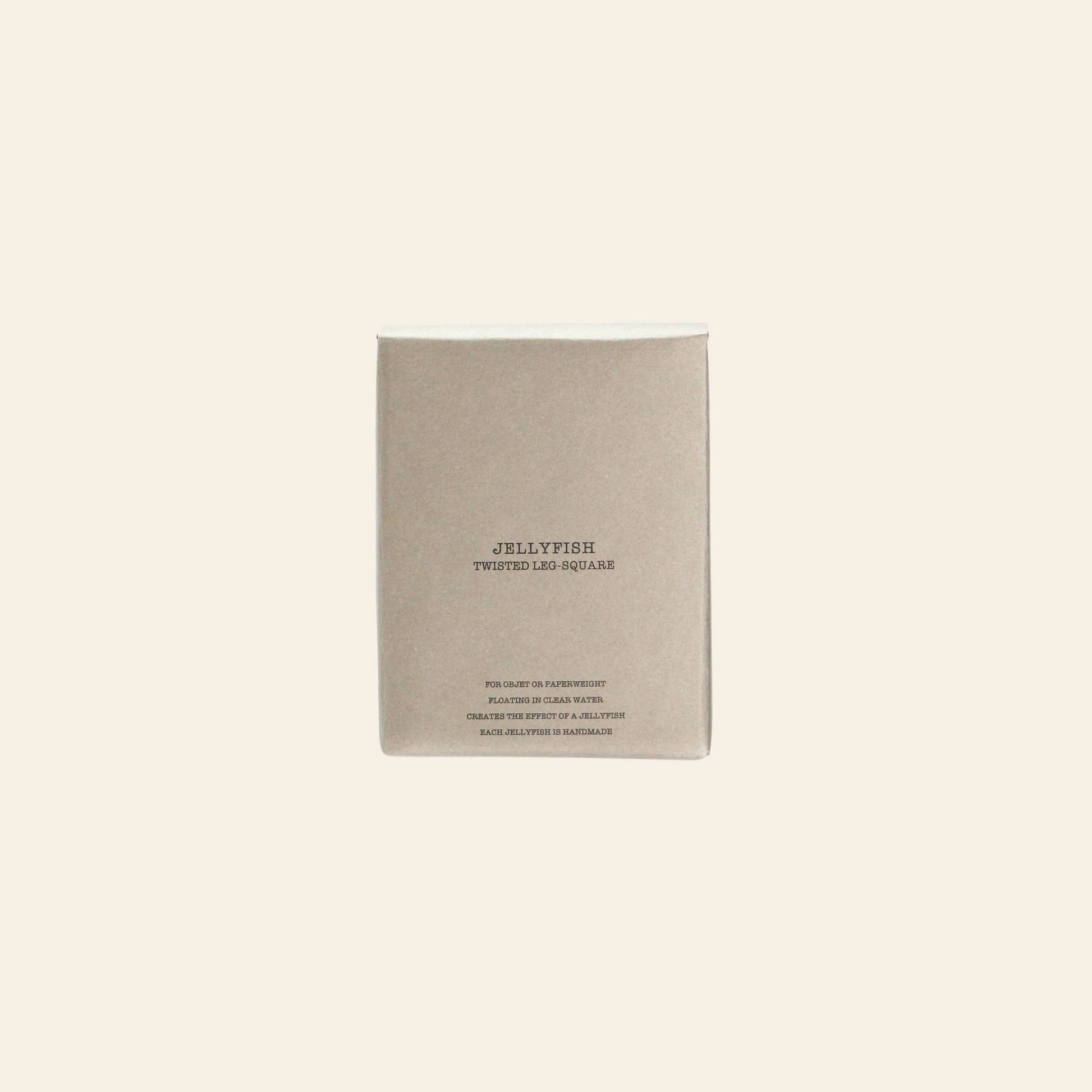 A minimalist beige box from DETAIL, labeled "DETAIL Jellyfish Twisted Leg Square," features centered text and a subtle abstract jellyfish design—ideal for modern décor fans. Displayed on a plain, light background for elegant appeal.