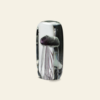 The DETAIL Jellyfish Twisted Leg Tall by DETAIL features a realistic purple jellyfish with long, thin tentacles encased in glass. Set against an off-white background, this modern art piece highlights delicate underwater beauty.
