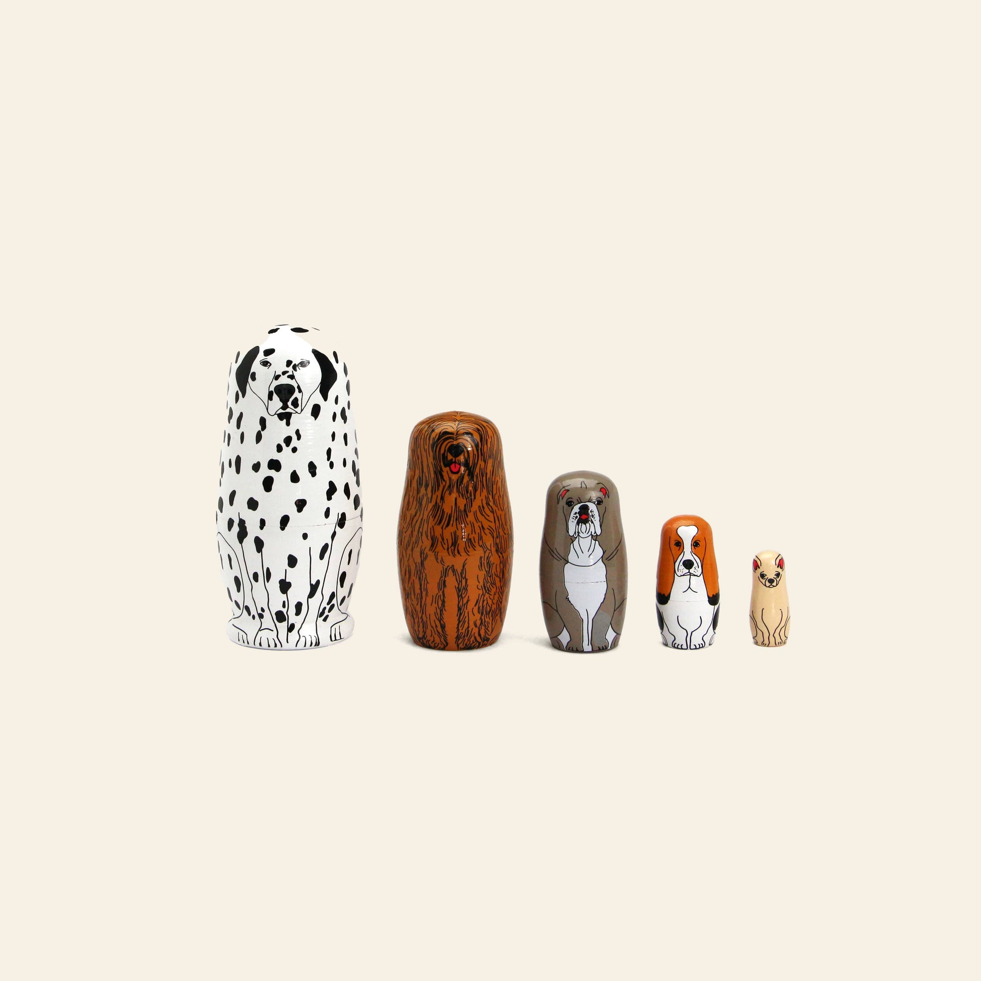 DETAIL Partners Nesting Dolls by DETAIL feature five hand-painted wood dolls, each with a unique dog design representing different breeds, arranged from largest to smallest against a beige background.