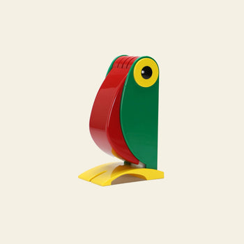 The DETAIL Toucan Lamp by DETAIL features a green body, red beak, yellow accents, and a yellow base in an abstract design, capturing vintage charm and standing upright against a plain light background.