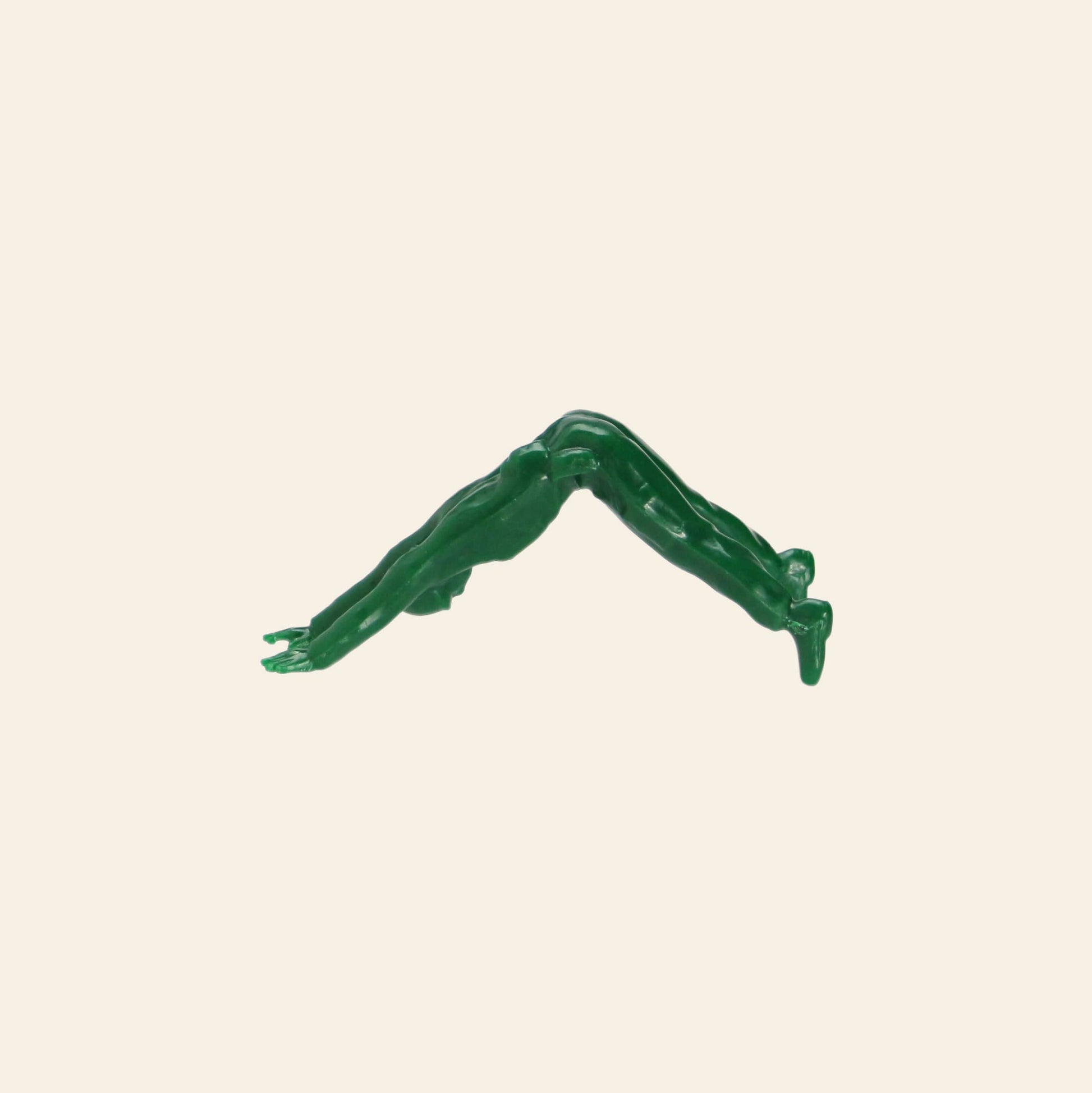 A DETAIL Yoga Joes 9 Figures toy from DETAIL in green is shown in a downward-facing yoga pose against a plain light beige background.