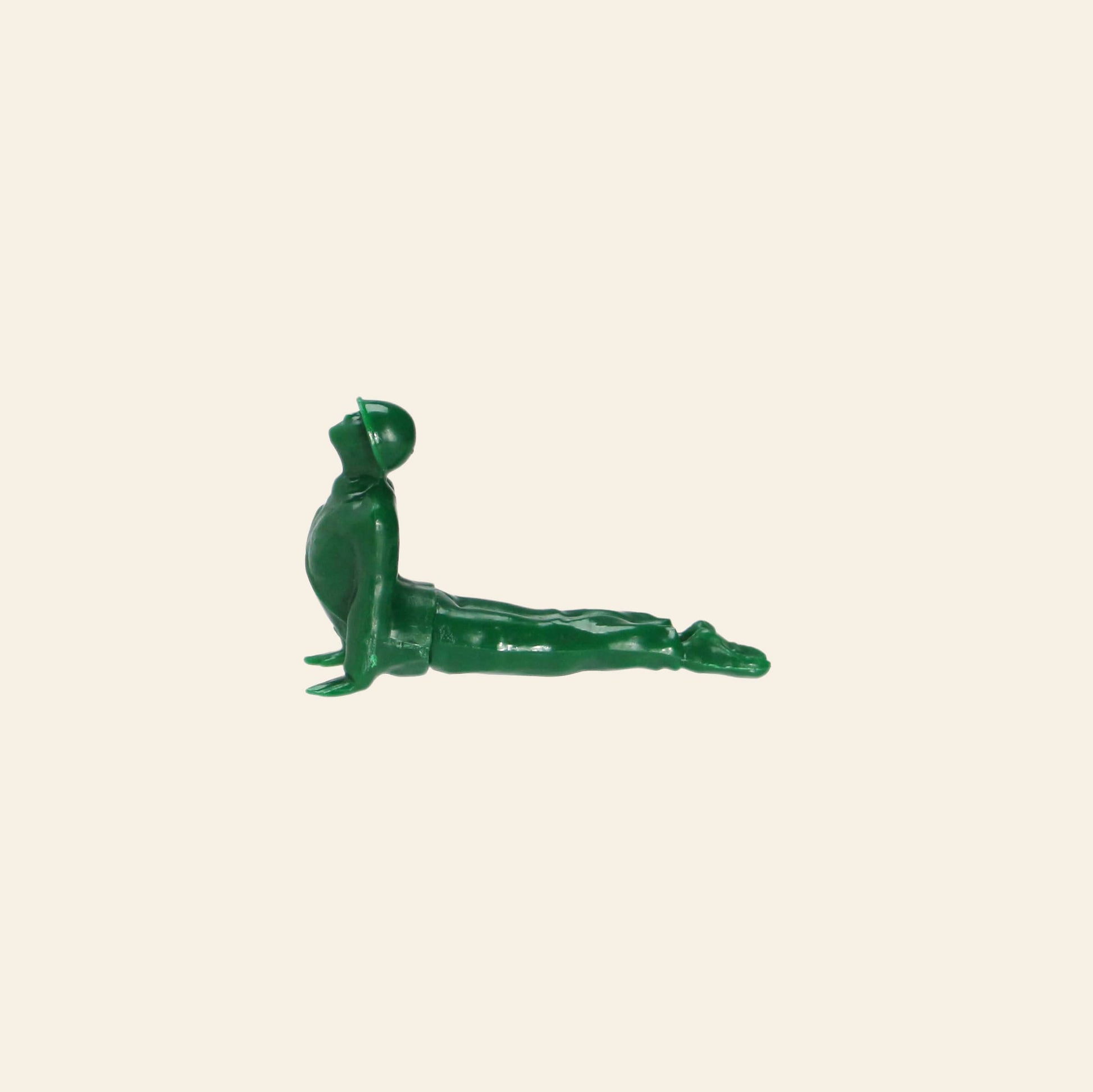A green plastic soldier from the DETAIL Yoga Joes 9 Figures collection by DETAIL is posed in an upward yoga stretch against a beige background.