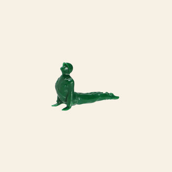 A DETAIL Yoga Joes 9 Figures green plastic soldier by DETAIL is posed in an upward-facing dog yoga stretch against a plain beige background.