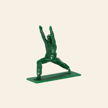 A DETAIL Yoga Joes 9 Figures toy soldier by DETAIL poses with arms raised and legs apart on a textured base, shown against a beige background.