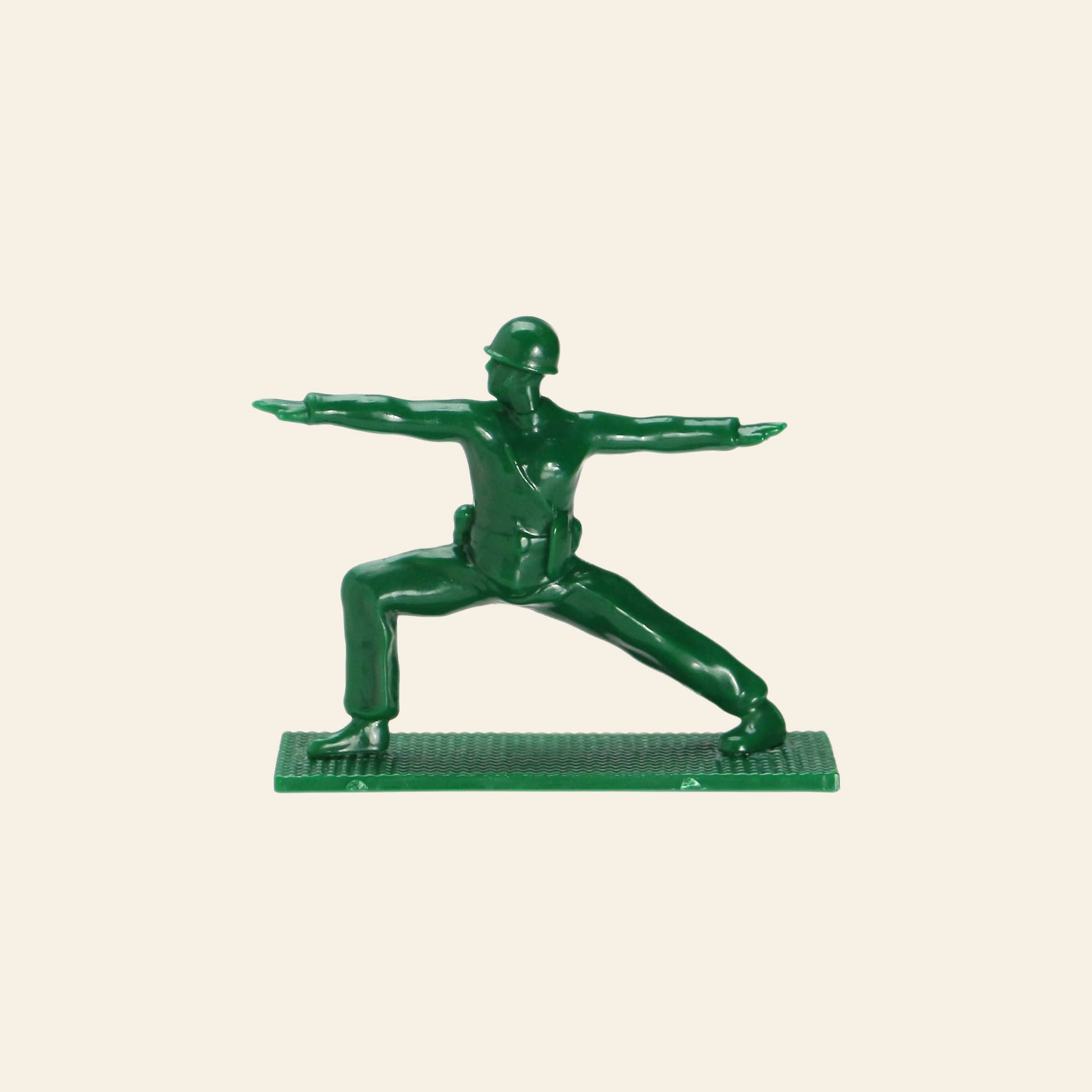A DETAIL Yoga Joes 9 Figures toy by DETAIL shows a green plastic soldier in a yoga warrior pose, arms extended and legs apart, standing on a textured rectangular base.