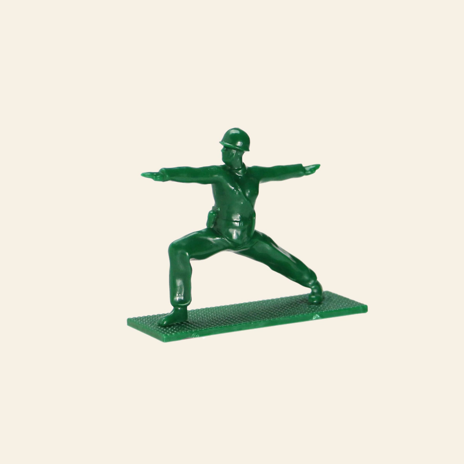 A DETAIL Yoga Joes figure from the 9-piece set by DETAIL strikes a yoga warrior pose on a rectangular base, displayed against a plain beige background.
