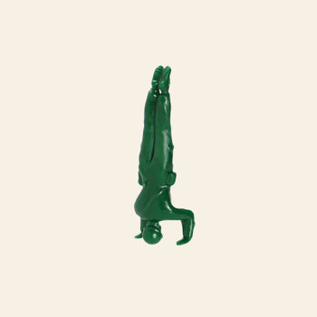 A DETAIL Yoga Joes 9 Figures green plastic toy soldier is balanced upside down on its head, legs straight up and arms bent, shown against a plain beige background.