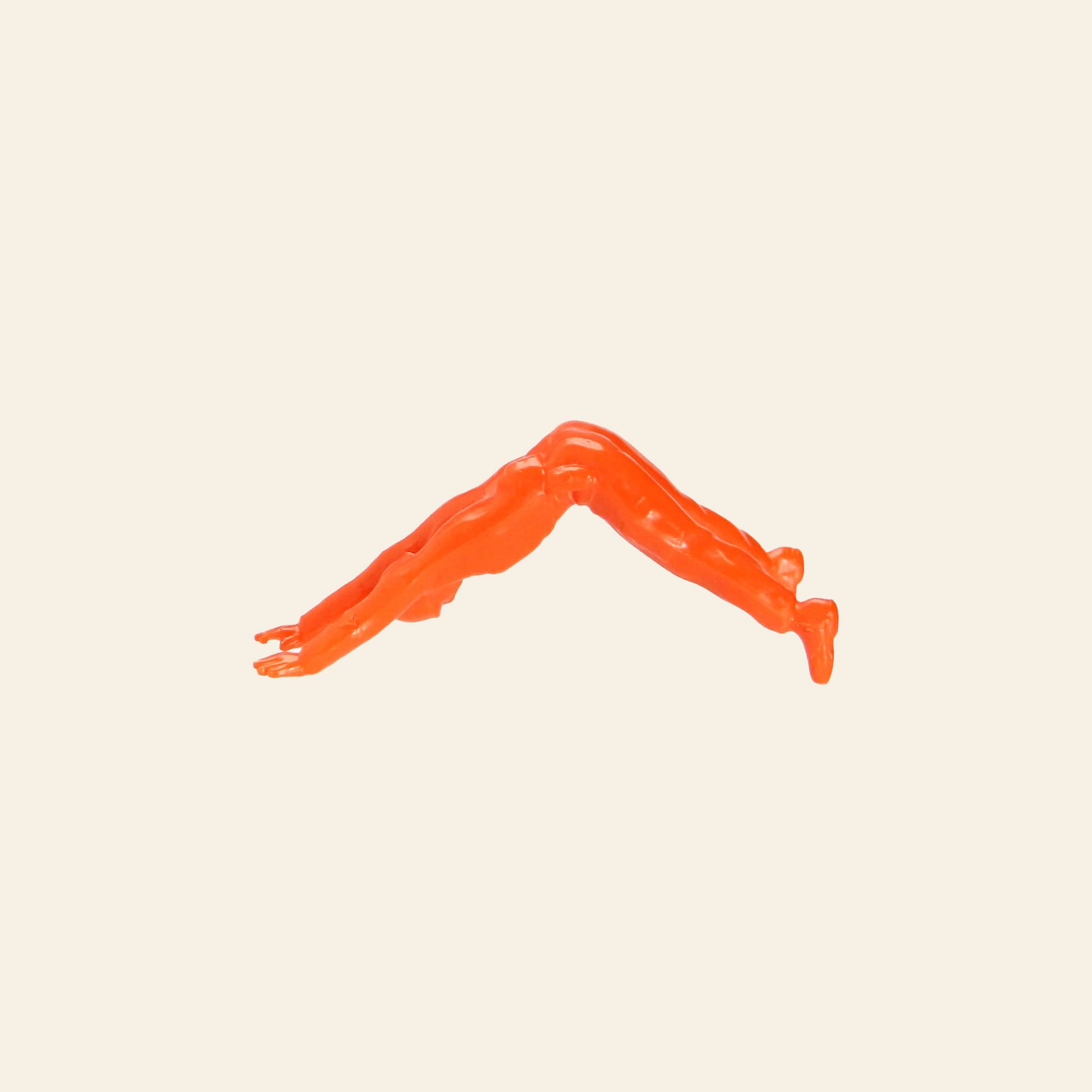 A DETAIL Yoga Joes 9 Figures orange figurine performs downward dog on a beige background—a playful DETAIL take on classic toy soldiers practicing yoga.