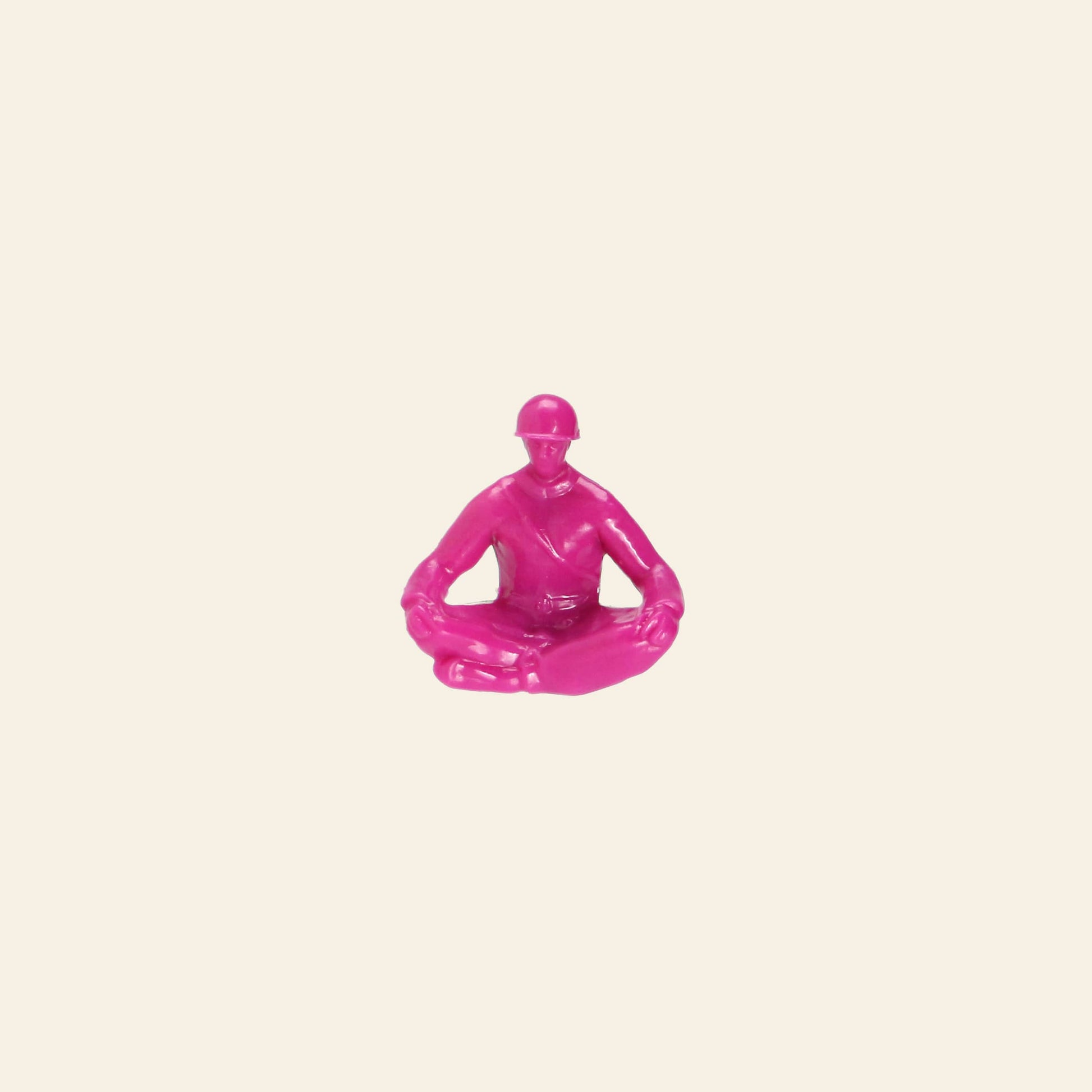 A small, pink figurine from DETAIL Yoga Joes 9 Figures by DETAIL sits cross-legged with hands on knees, centered on a plain light beige background.