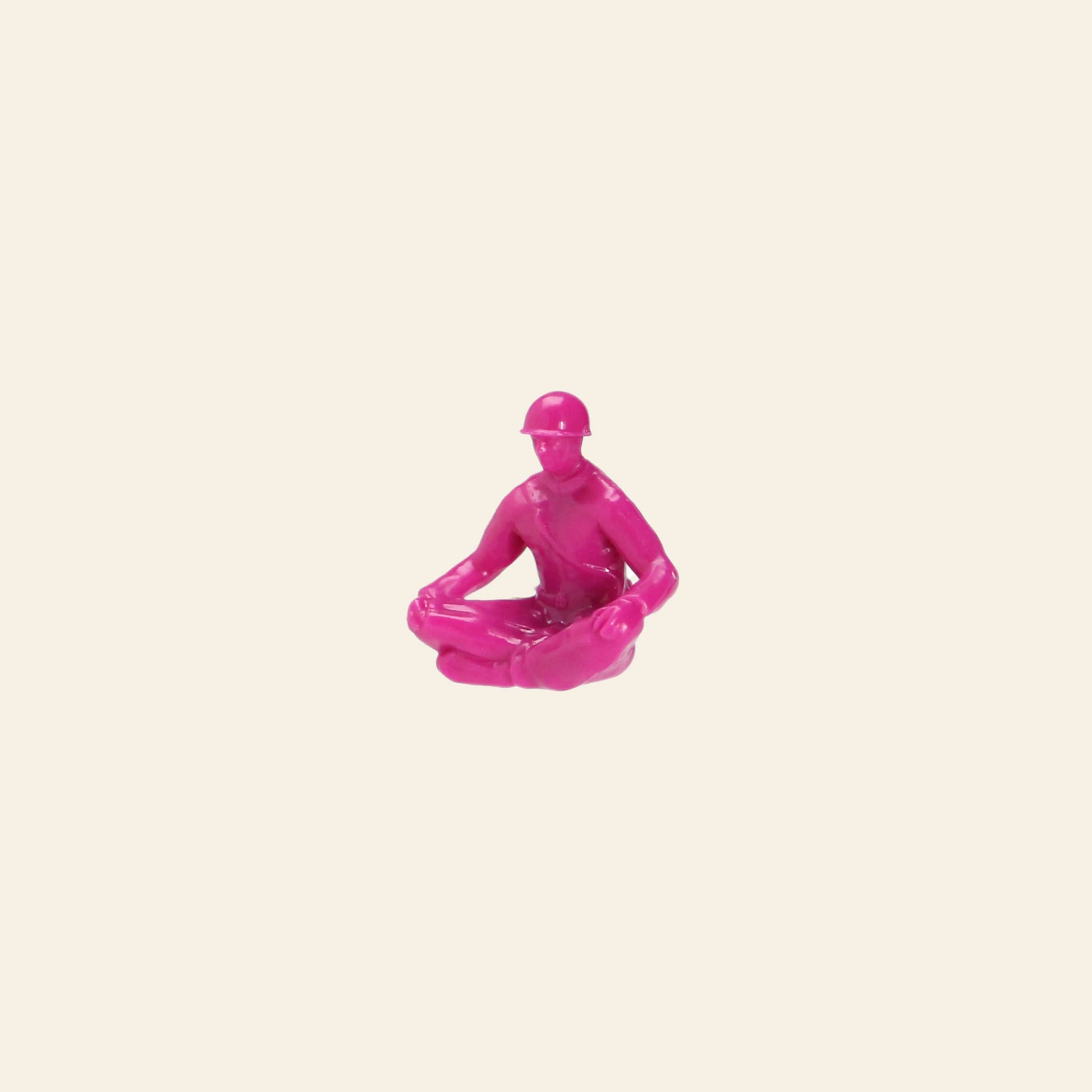 A DETAIL Yoga Joes figure from the 9-piece set, by DETAIL, sits cross-legged in a meditative pose against an off-white background.
