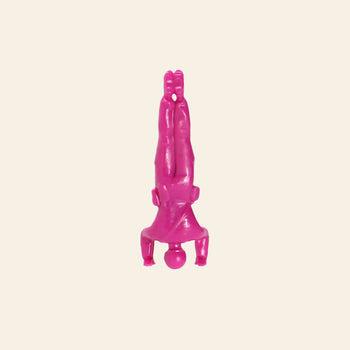 A small pink plastic figurine from DETAIL Yoga Joes 9 Figures by DETAIL shows a person in a headstand, legs together and arms bent, against a light background—ideal for Yoga Joes or toy soldier yoga enthusiasts.