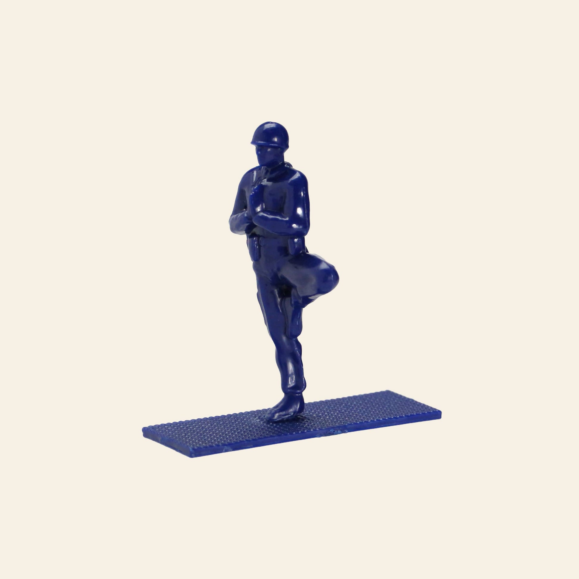 A DETAIL Yoga Joes 9 Figures toy soldier by DETAIL stands upright on a textured base, holding a rifle across its chest, set against a plain light background.