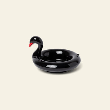 The DOIY Black Swan Floatie Bowl by DOIY, featuring a red beak, is displayed on a plain light background, making it a striking decorative accent for your next pool day.
