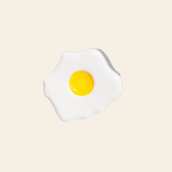 The DOIY Fast Food Fried Egg Trinket Tray by DOIY features a bright yellow yolk and wavy white on a light beige base—ideal for adding retro charm to your décor.