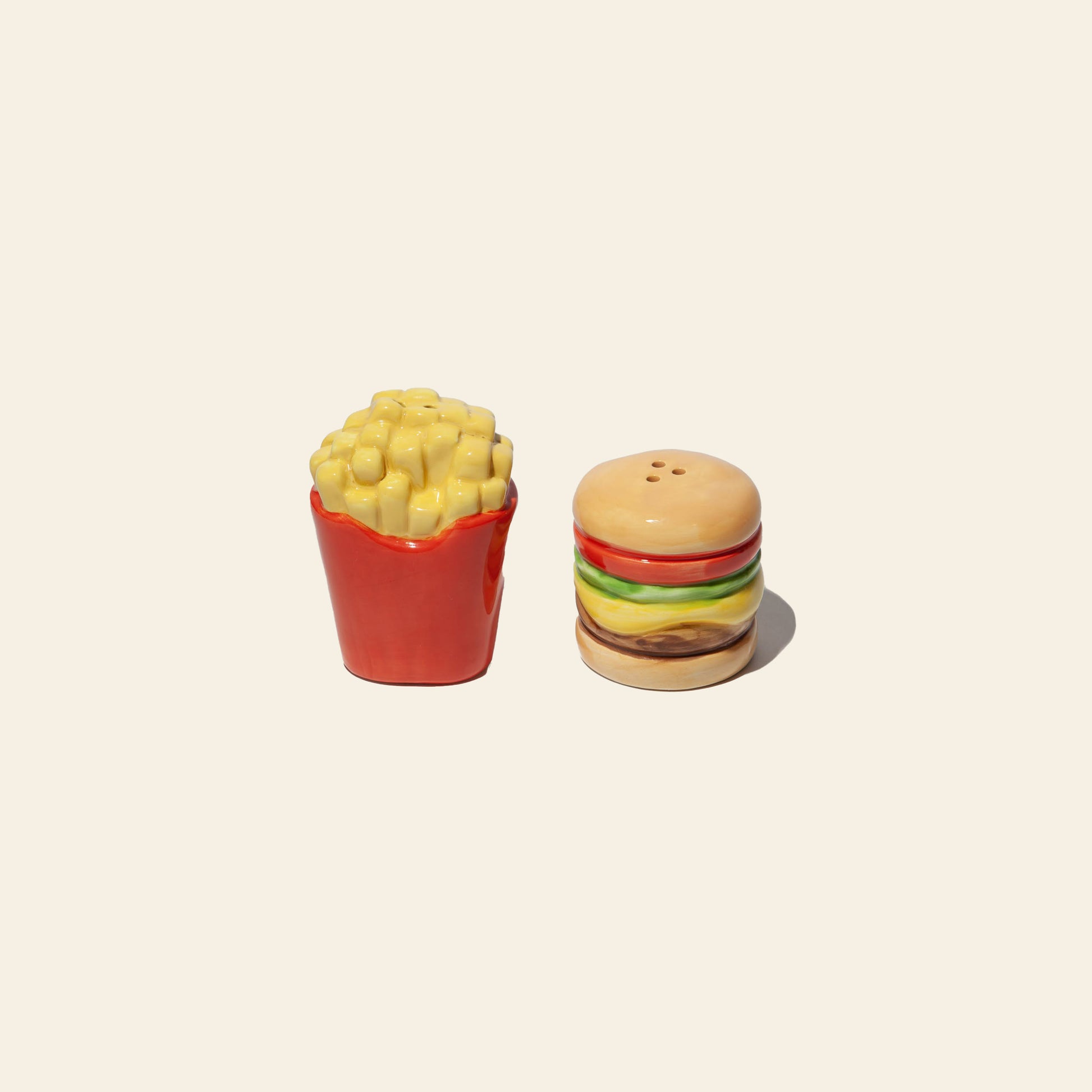 The DOIY Fast Food Fries & Burger Salt & Pepper Set by DOIY features ceramic shakers shaped like fries and a burger, bringing playful, vintage charm to your table or retro kitchen accessories collection.