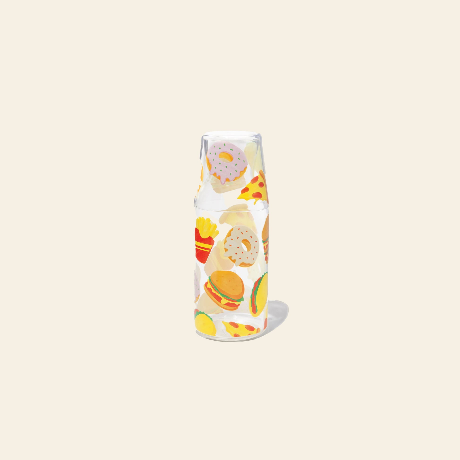 The Stacked Store DOIY Fast Food Jar & Glass Set includes a clear diner glass cup atop a matching jar, both decorated with vibrant images of burgers, pizza, fries, tacos, and donuts on a plain beige background.