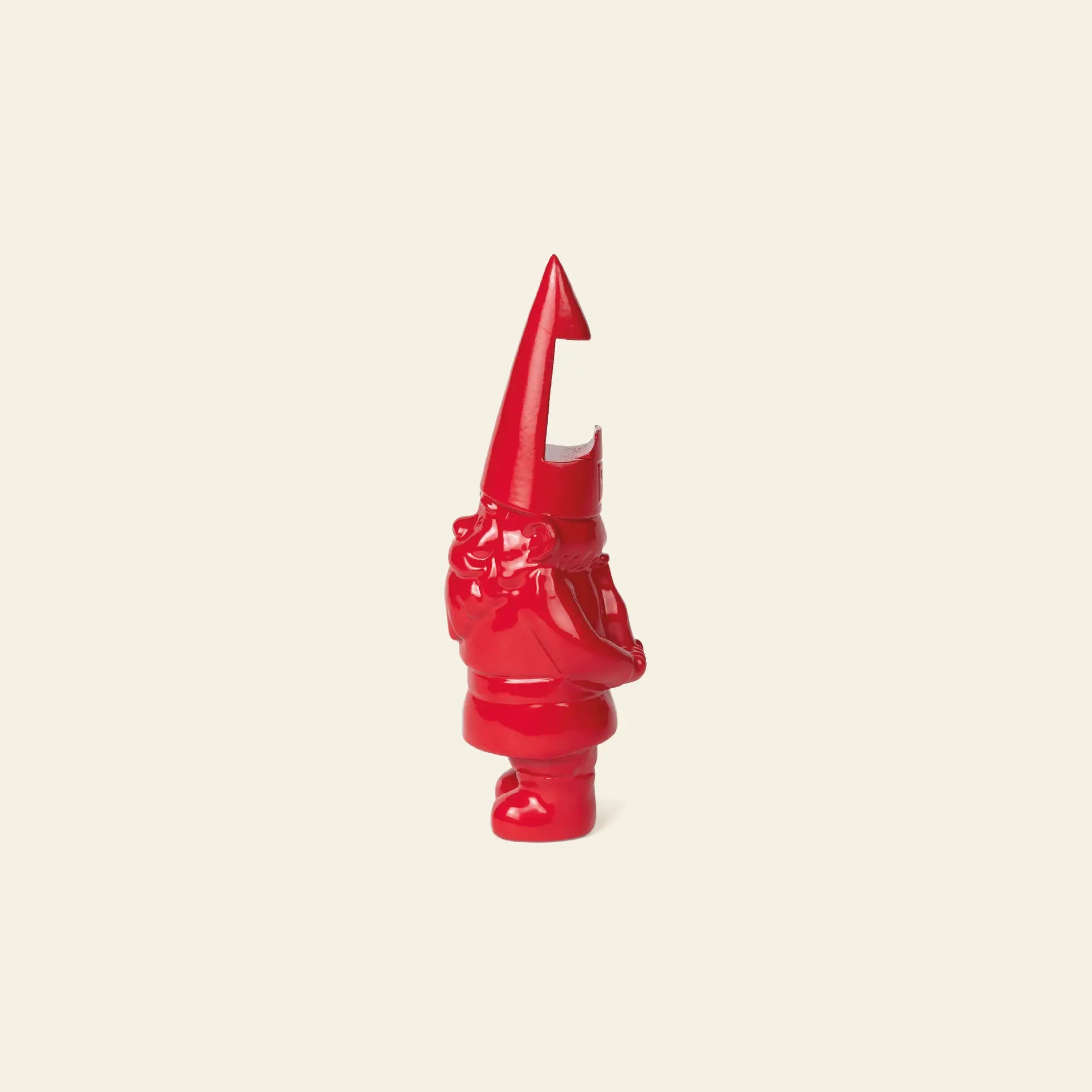 The DOIY Gnome Bottle Opener by DOIY is a glossy red figurine with a tall, pointed hat and beard, shown in profile against a plain light beige background.