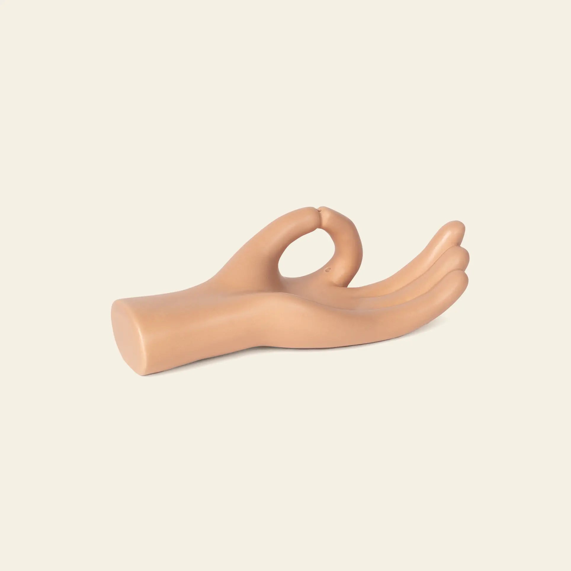 The DOIY Om Meditation Hand Incense Holder by DOIY features a sculpted beige hand making an OK gesture, designed to rest on its side against a plain, light background.