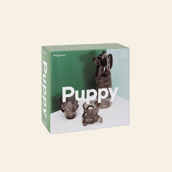 A box labeled DOIY Puppy Glasses, Set of 4, displays stackable brown dog-shaped glasses by DOIY in various sizes on a green and white background. The #doglover hashtag appears in the top left corner.