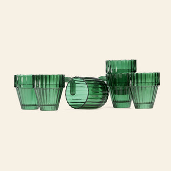 The DOIY Saguaro Glasses, Set of 6 by DOIY features green ribbed tumblers arranged with five upright in a semicircle and one on its side, creating a stylish display against a light background for modern home decor.