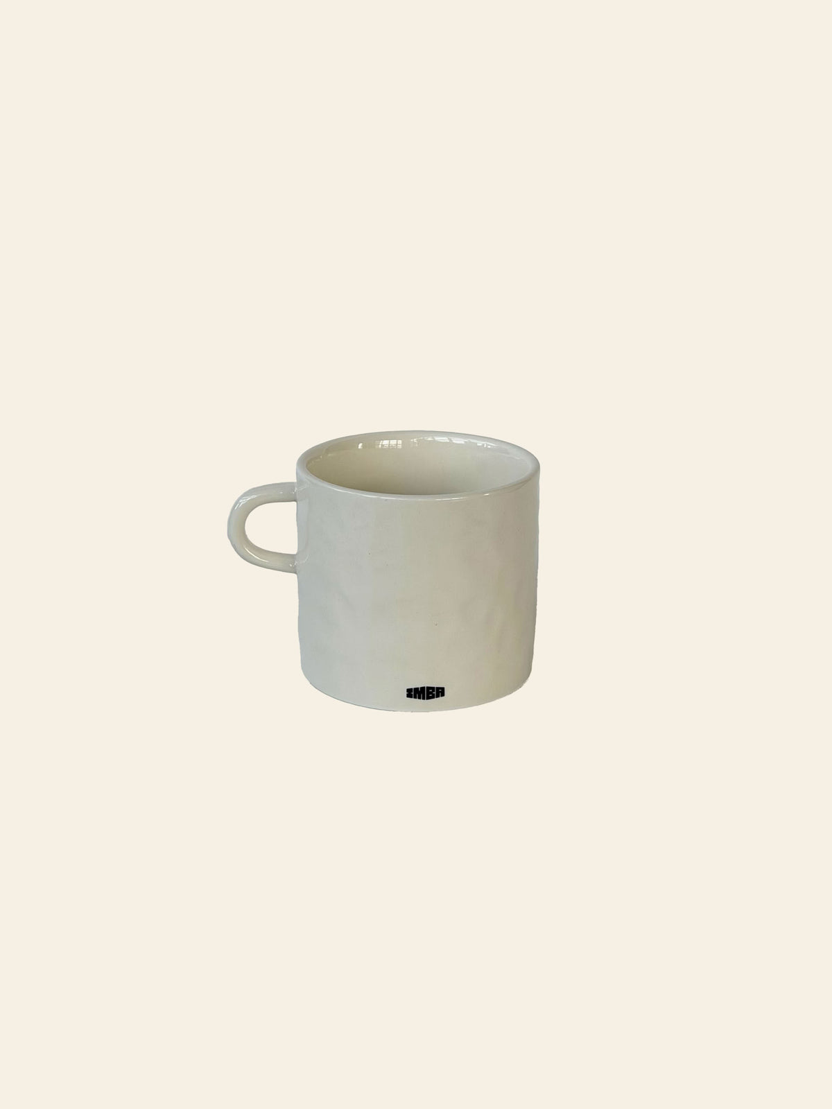 A plain white ceramic mug with a handle, featuring a small, subtle black “Love Life” logo on the front, sits on a neutral light beige background. This is the David Hockney Love Life Mug by David Hockney.