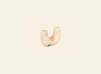The Dinosaur Designs Mini Branch Vase is a small, U-shaped marbled beige and cream ceramic piece with two openings, shown against a plain off-white background.