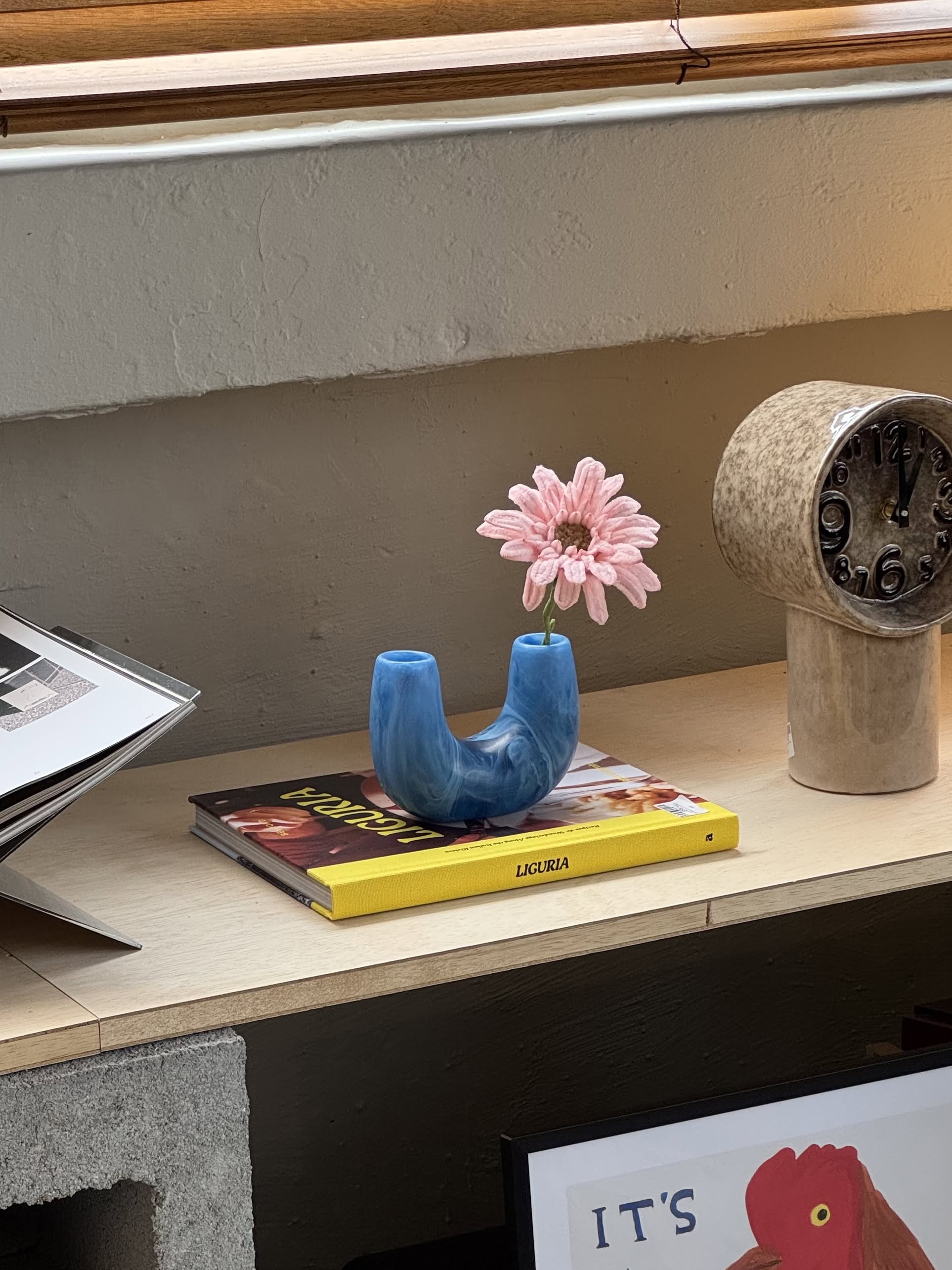 The Dinosaur Designs Mini Branch Vase, a blue U-shaped ceramic piece with two openings, stands upright against a plain light beige background.