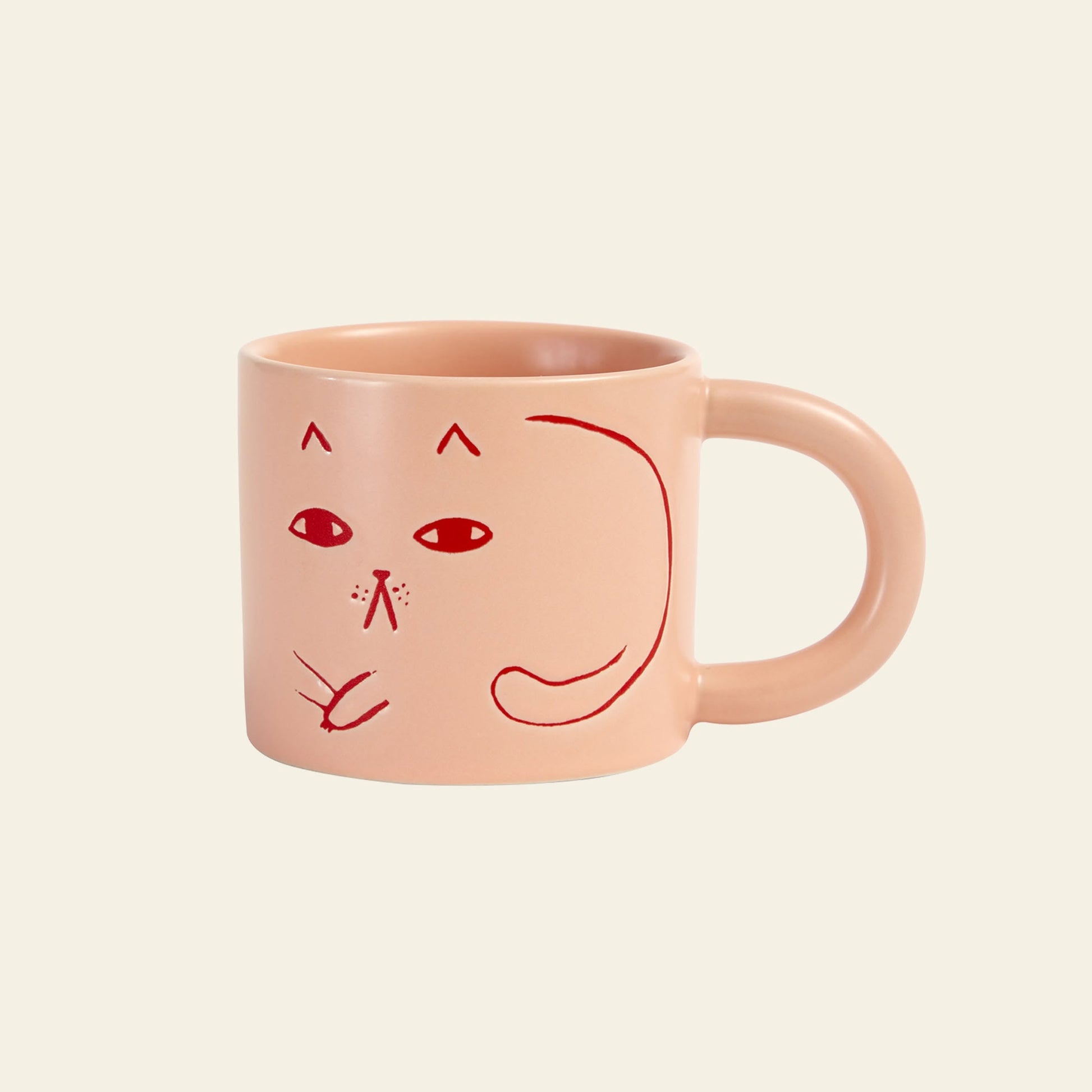 The Donna Wilson Cat Mug by Donna Wilson features a light pink design with a simple red line drawing of a cats face and tail—an adorable way to add playful charm to your coffee break.