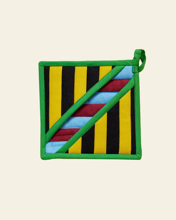 The Dusen Dusen Pocket Pot Holder by Dusen Dusen is a heat-resistant square kitchen accessory with green edging, featuring vertical black and yellow stripes on one side and diagonal blue and maroon stripes on the other.