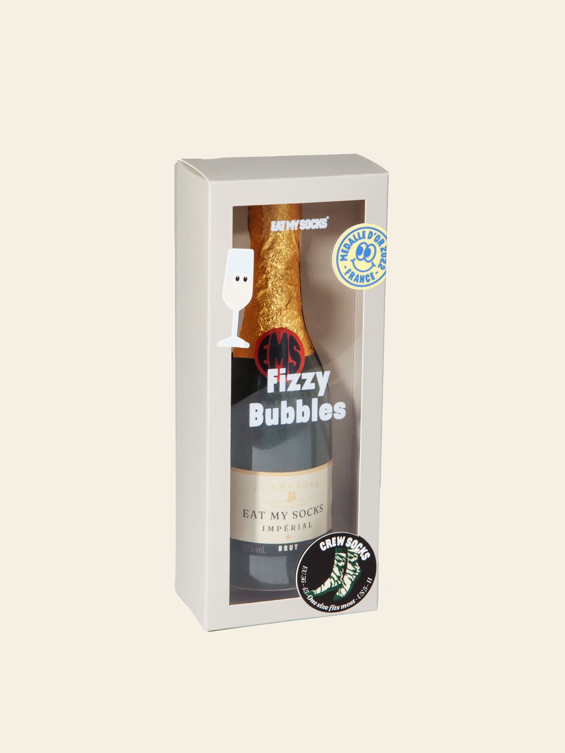 A boxed gift set featuring Eat My Socks Rosé Bubbles Socks by Eat My Socks, with a gold-wrapped bottle labeled “Eat My Socks” and “Fizzy Bubbles” that resembles champagne, all presented in clear packaging adorned with playful graphics and text. This delightful unisex gift includes socks with abstract patterns inspired by the effervescent spirit of celebration.