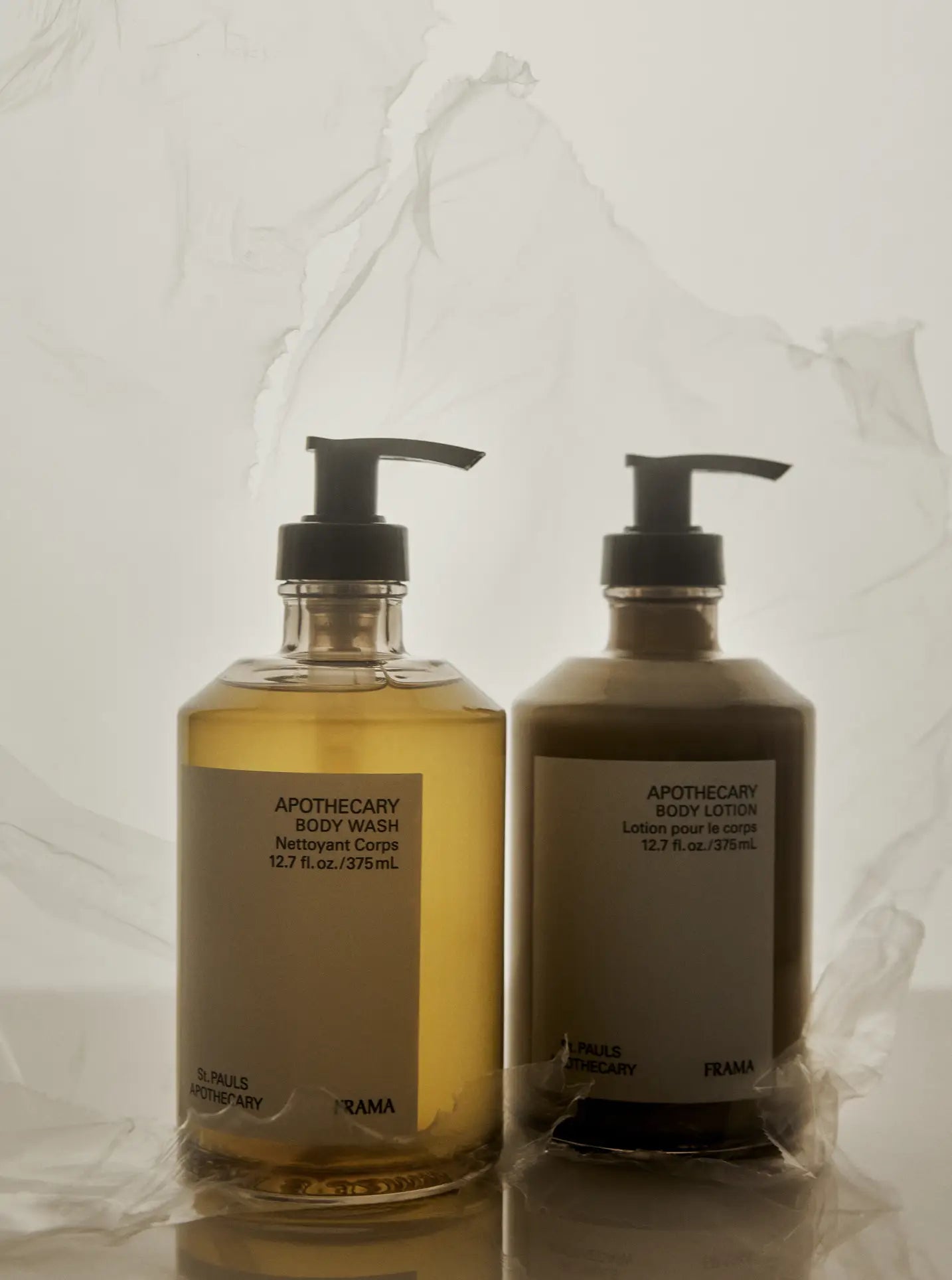 Two pump bottles labeled FRAMA Body Wash, 375ml stand side by side against a soft, translucent background, their minimalistic white labels reflecting the soothing essence of this fragrant cleansing gel from FRAMA.
