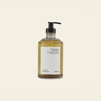 A clear pump bottle of amber-hued FRAMA Hand Wash (375ml), featuring sandalwood and organic ingredients, is displayed against a plain light background.