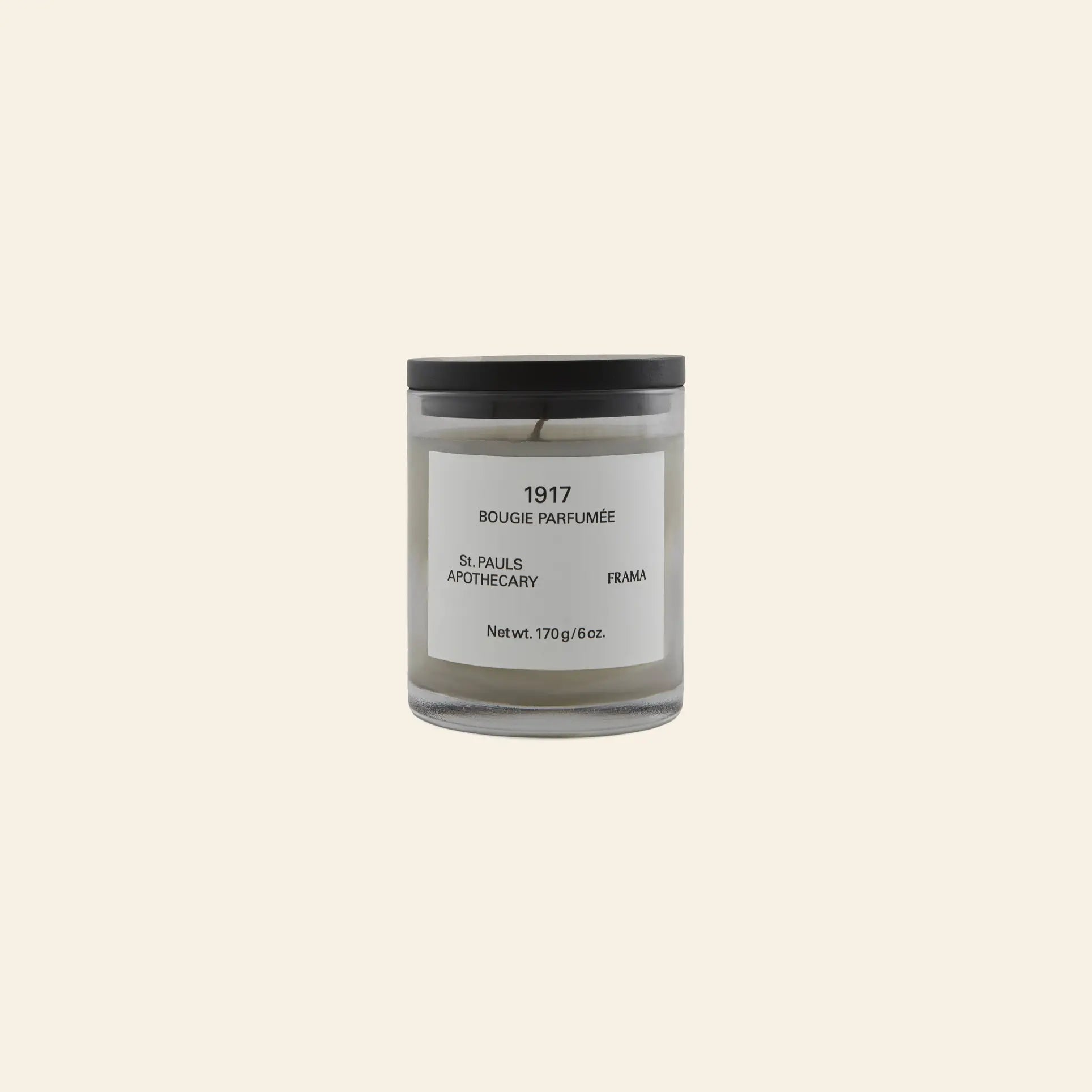 The FRAMA 1917 Scented Candle, 170g, features a minimalist glass jar with a black lid and white label. Inspired by Mediterranean flora and classical Chypre notes, it brings elegant fragrance to your space.