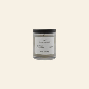 The FRAMA 1917 Scented Candle, 170g, features a minimalist glass jar with a black lid and white label. Inspired by Mediterranean flora and classical Chypre notes, it brings elegant fragrance to your space.