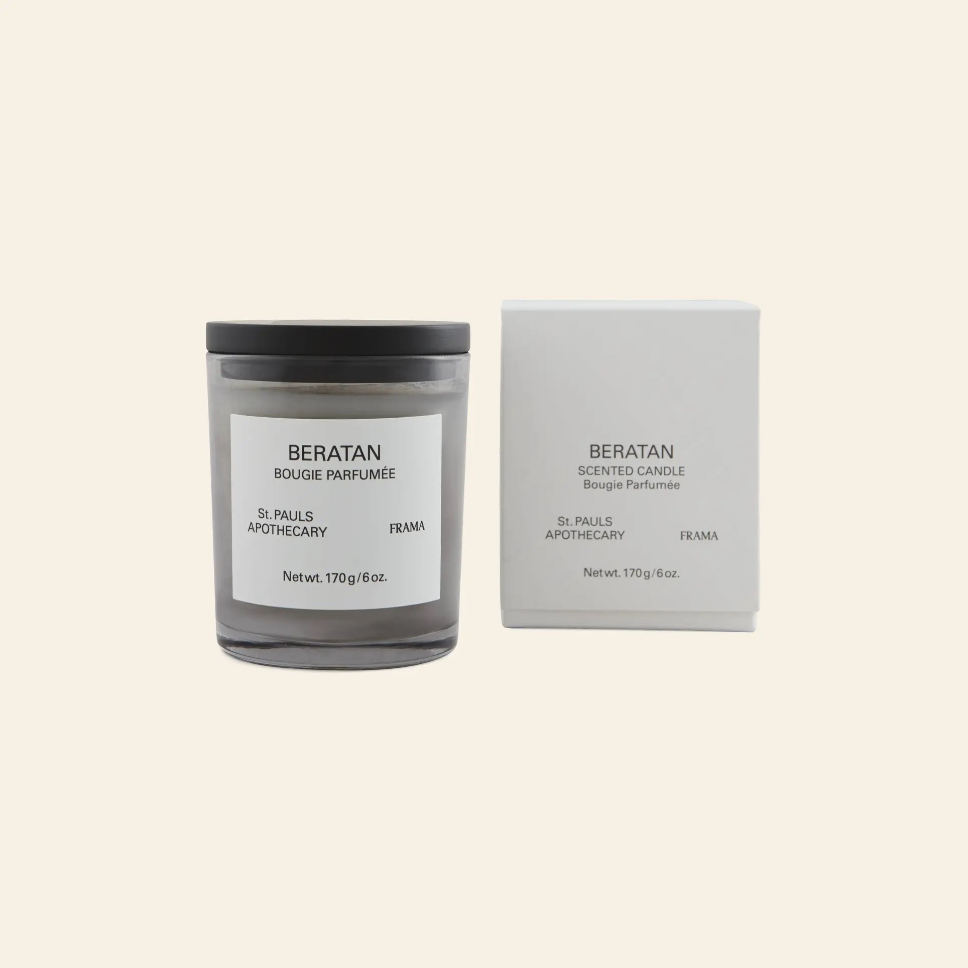 The FRAMA Beratan Scented Candle, 170g, in a glass jar with black lid sits beside its matching white box. Both are labeled FRAMA; its warm scent adds a tropical ambiance to any space.