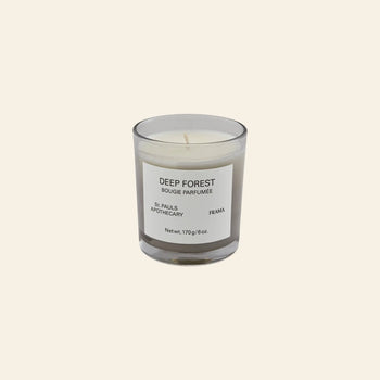 The FRAMA Deep Forest Scented Candle, 170g, features an earthy Abies fir-inspired aroma in a glass jar labeled Bougie Parfumée by St. Pauls Apothecary and FRAMA, shown against a plain beige background.