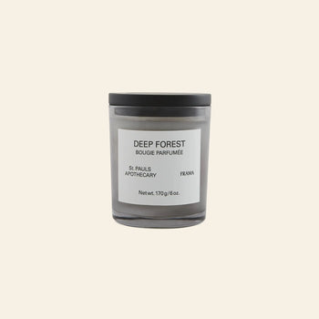 The FRAMA Deep Forest Scented Candle, 170g, comes in a black glass jar with a white DEEP FOREST label and black lid. Set against a light beige background, its earthy fragrance evokes Abies fir woods.