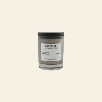 The FRAMA Deep Forest Scented Candle, 60g, features minimalist design and branding. Its glass jar holds a fragrance inspired by Abies fir woods, shown against a plain beige background.