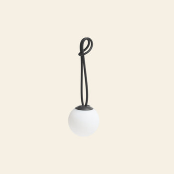 The Fatboy Bolleke Mini La Surprise by Fatboy is a round white spherical lamp with a black cord, shown against an off-white background. It features adjustable dimming for customized lighting.