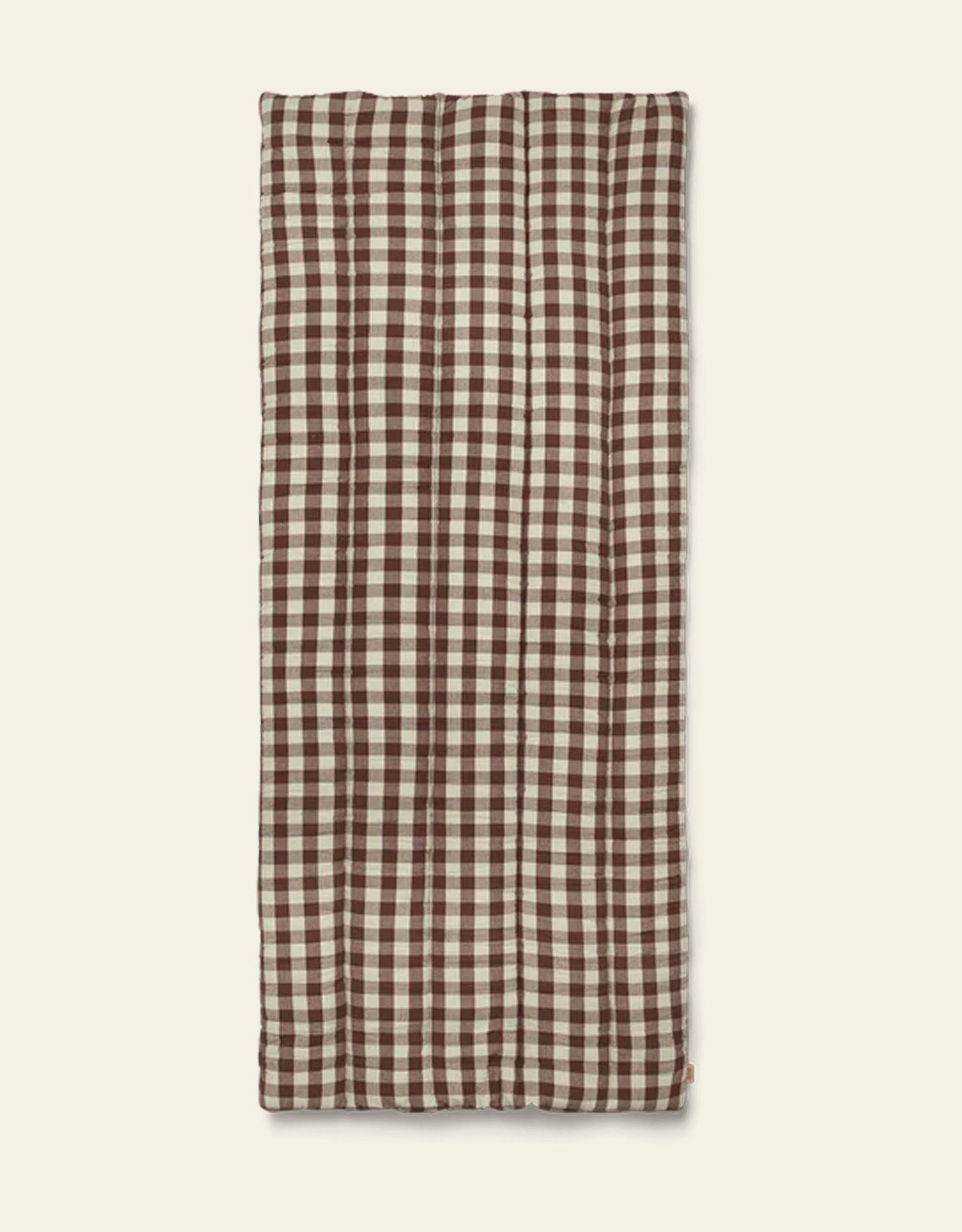 The Ferm Living Bothy Check Quilted Mattress features a brown and white gingham pattern, laid flat on a beige background—ideal for bringing rustic charm to your home decor.