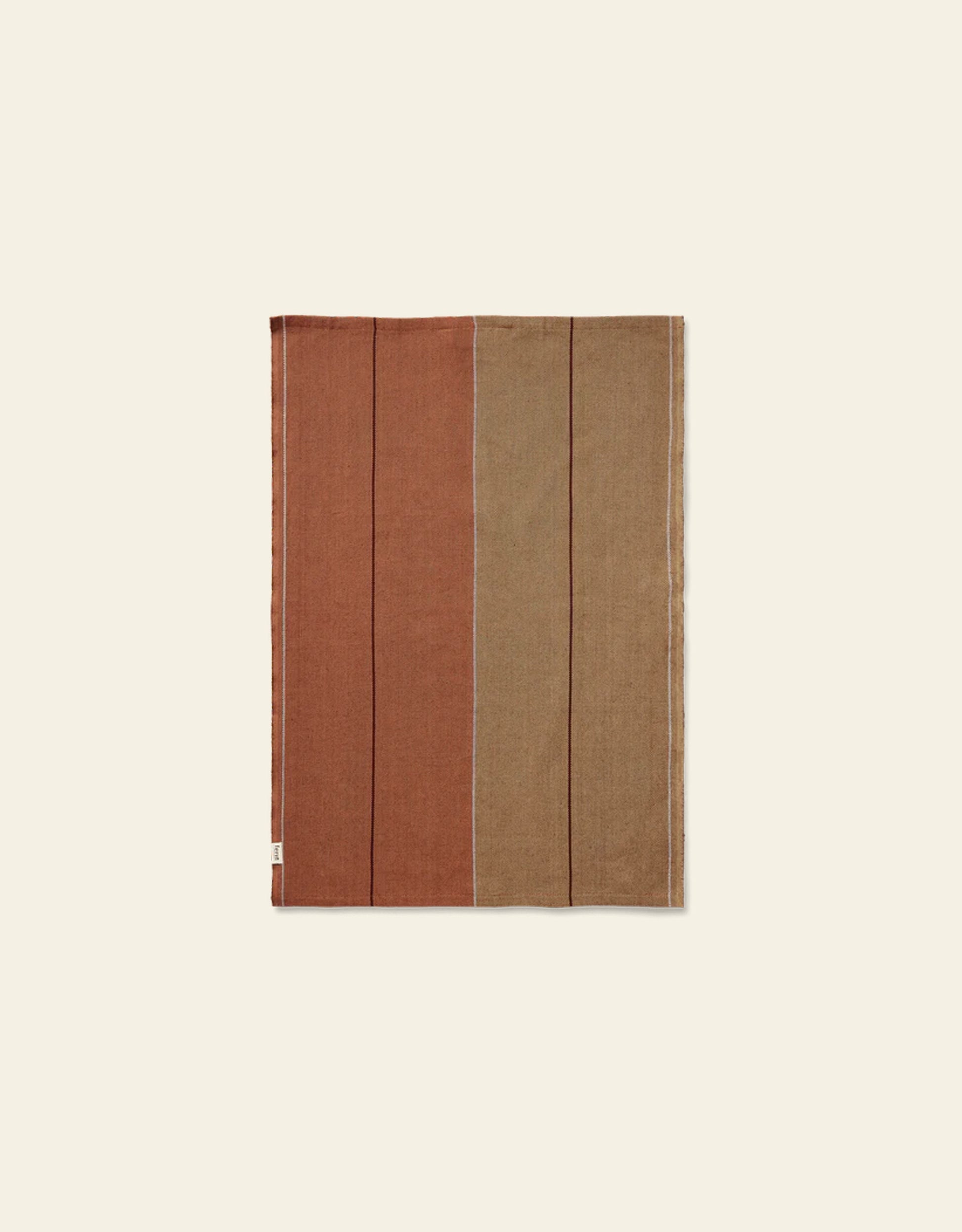 The Ferm Living Ito Tea Towel, Set of 2, by Ferm Living, features a rectangular design in organic cotton twill with earthy rust and brown vertical blocks on a light beige background.