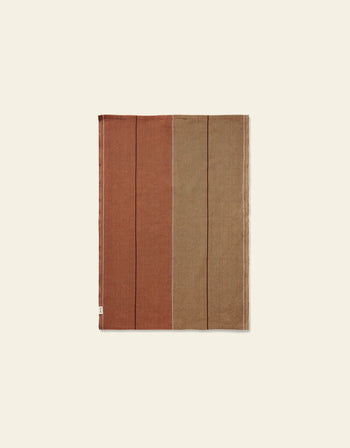 The Ferm Living Ito Tea Towel, Set of 2, by Ferm Living, features a rectangular design in organic cotton twill with earthy rust and brown vertical blocks on a light beige background.