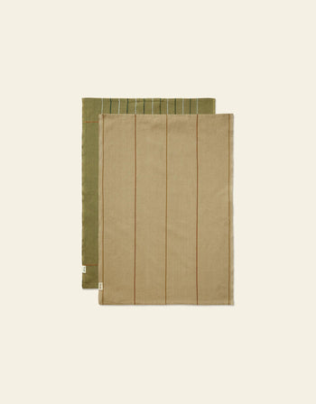 The Ferm Living Ito Tea Towel Set of 2, featuring olive green with white stripes and beige with brown stripes in a soft twill weave, is neatly folded and displayed on an off-white background.